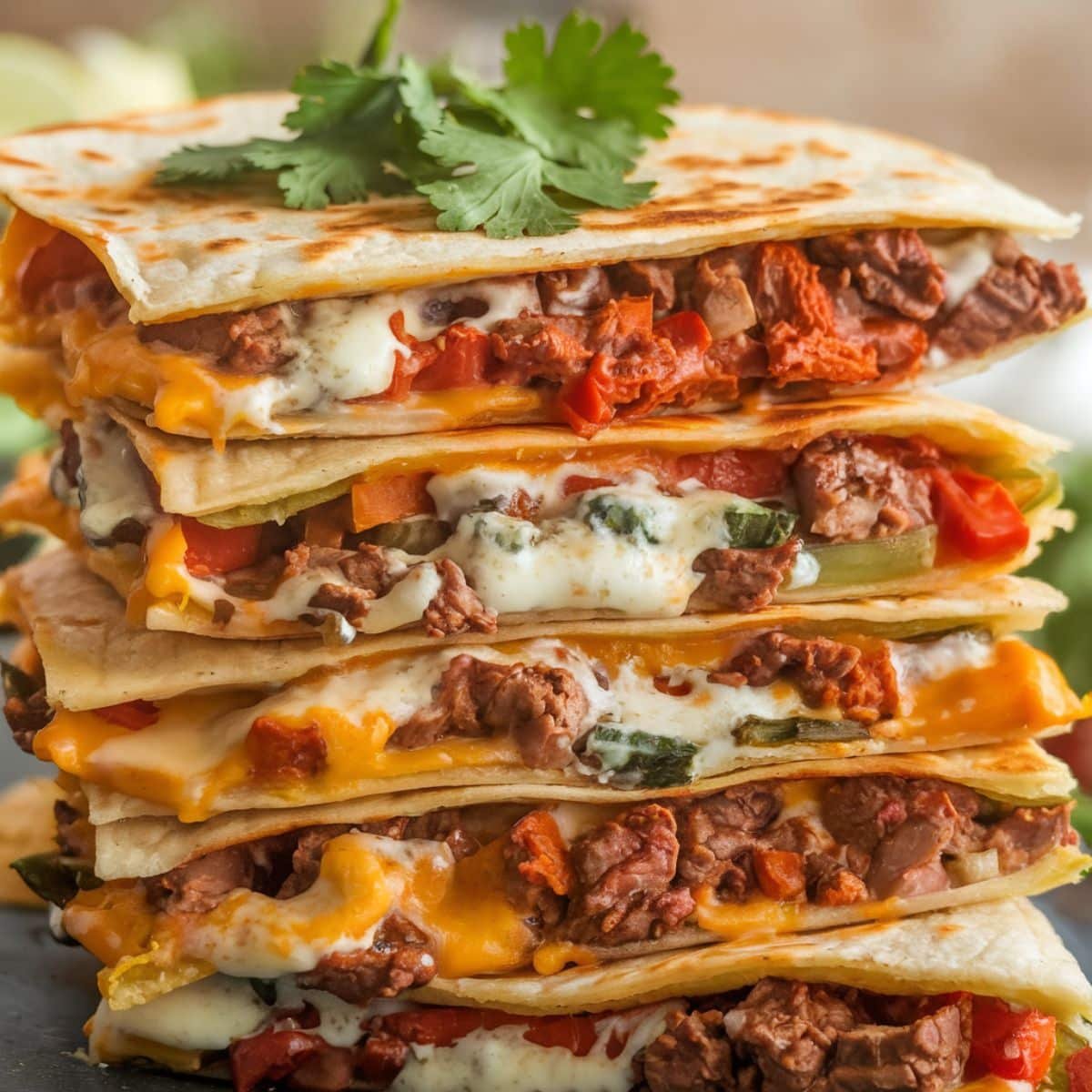 Stacked cheesy Steak Quesadillas filled with tender steak, melted cheese, and sautéed vegetables, garnished with fresh cilantro, showcasing the ultimate Steak Quesadilla Recipe.