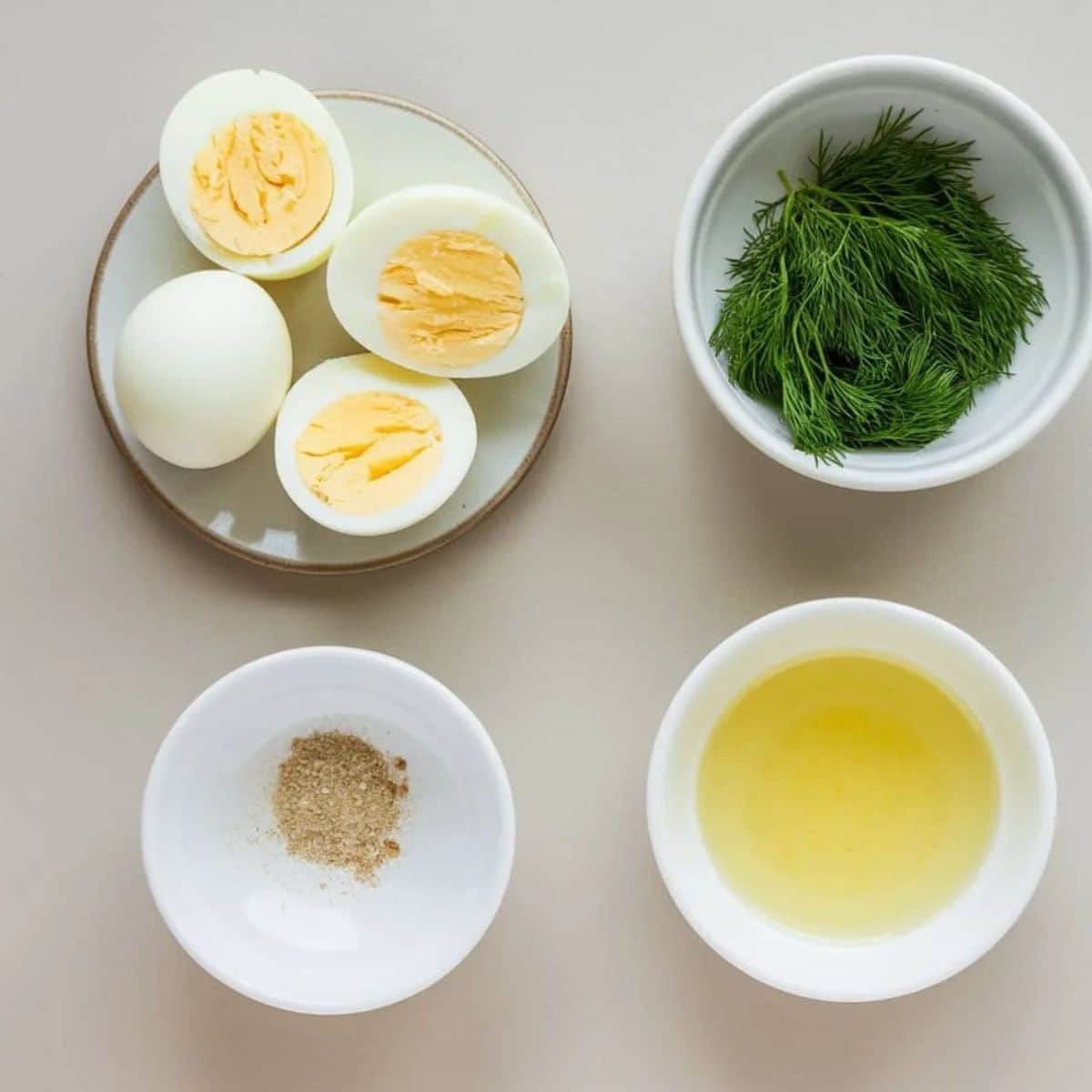 Classic add-ins for a Chicken Salad Chick recipe, featuring hard-boiled eggs, fresh dill, seasoning, and a small bowl of olive oil, perfect for enhancing flavor and texture.