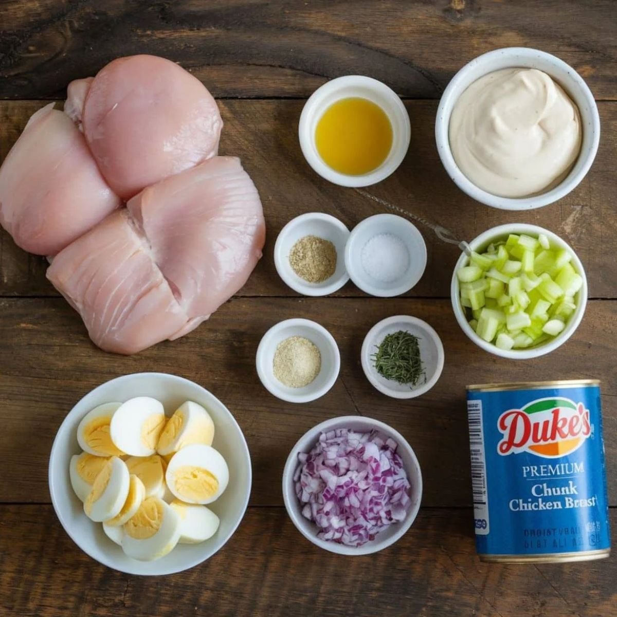 Chicken Salad Chick Recipe Ingredients – Fresh Chicken, Mayo, Celery, Red Onion, Hard-Boiled Eggs, and Seasonings on a Rustic Wooden Background.