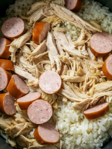 A close-up of Chicken Bog Recipe, a traditional Southern one-pot dish, featuring tender shredded chicken, smoked sausage slices, and seasoned rice cooked together in a flavorful broth. This comforting and hearty Carolina-inspired recipe is known for its rich taste and satisfying texture.