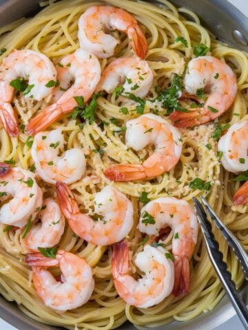 A savory pan of Garlic Butter Shrimp and Pasta, featuring succulent shrimp cooked in a rich garlic butter sauce, served over perfectly cooked spaghetti and garnished with fresh parsley and Parmesan. A delicious and easy seafood pasta dish bursting with flavor.