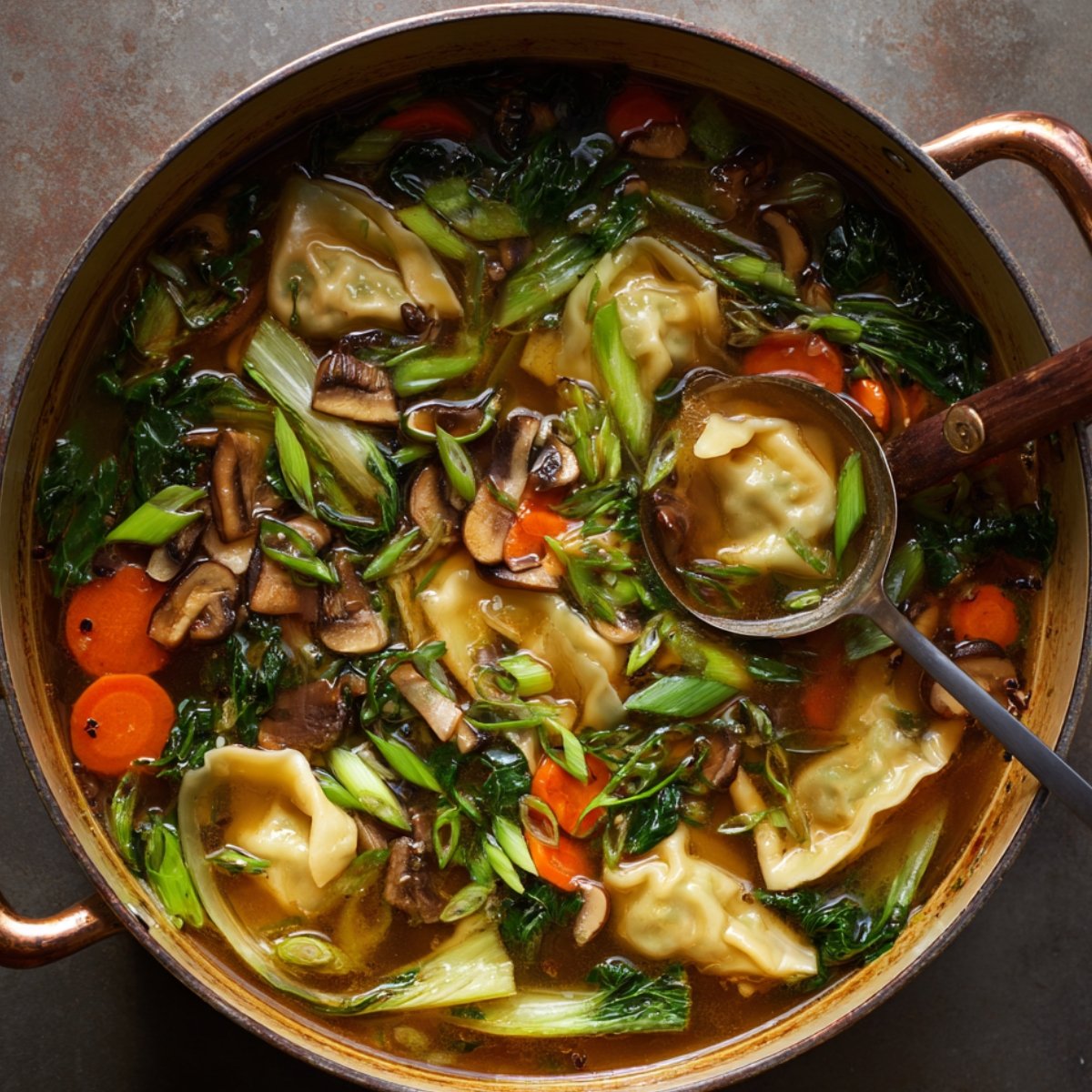 Homemade potsticker soup simmering with dumplings, mushrooms, bok choy, and carrots in a flavorful broth.