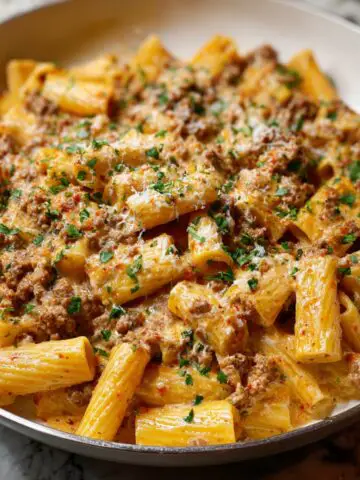 Creamy Italian Sausage Rigatoni topped with fresh parsley and grated cheese.