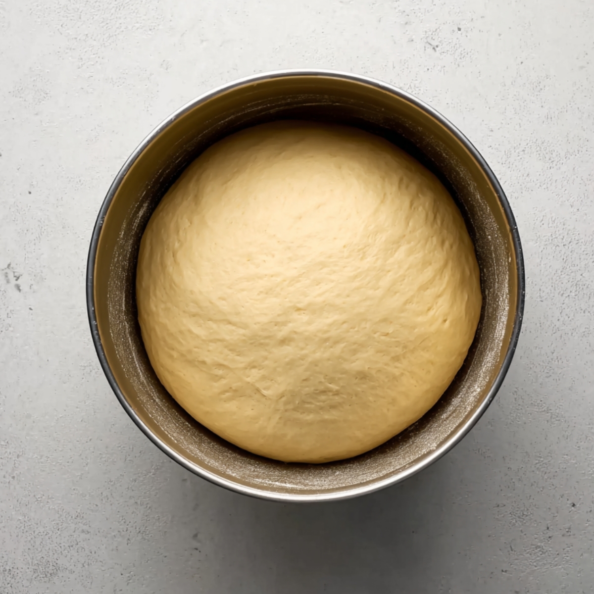 Warm the milk and butter together in a small saucepan over low heat until the butter melts completely. Let it sit until it's just lukewarm to the touch. Pour it into your stand mixer bowl fitted with the dough hook, then add the honey, eggs, bread flour, yeast, and salt. Mix on low speed for about a minute until everything comes together into a shaggy dough. Bump the speed up to medium and let it knead for 6 minutes. The dough should pull away from the sides of the bowl and feel smooth and elastic, not sticky. Transfer it to a lightly greased bowl, cover it with a towel.