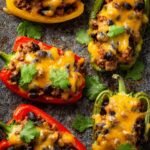 A delicious close-up of Bell Pepper Nachos halves stuffed with seasoned ground beef, black beans, corn, and melted cheese, garnished with fresh cilantro.