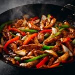 Spicy Black Pepper Chicken stir fry with vegetables, glossy sauce, cooking in a pan