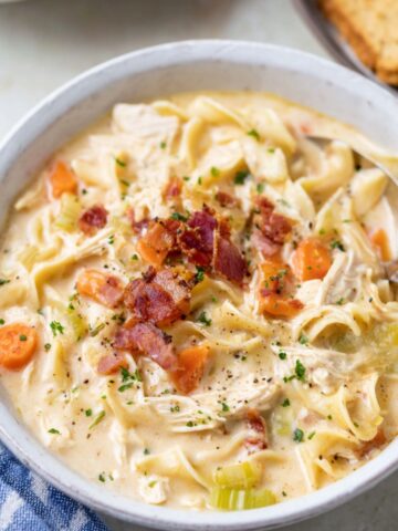 Bowl of creamy Crack Chicken Noodle Soup with noodles, bacon, and vegetables