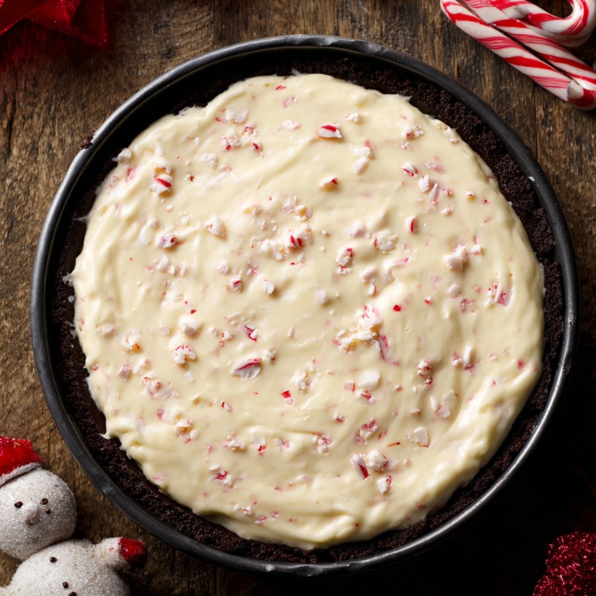 Pour the cheesecake batter over the cooled Oreo crust, spreading it evenly.