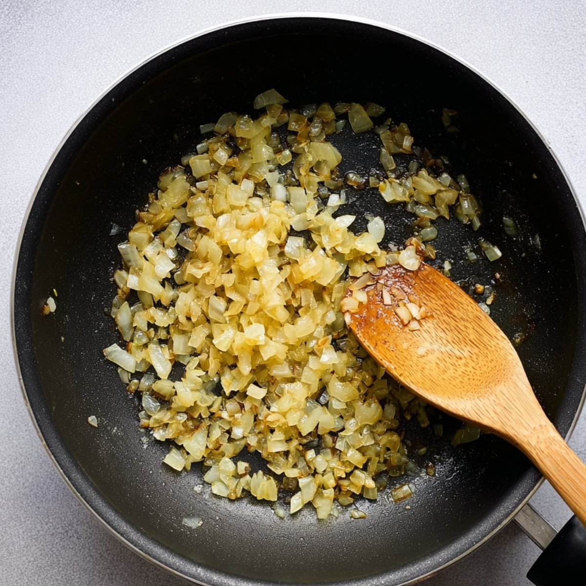 Sautéing chopped onions in a pan until golden brown.