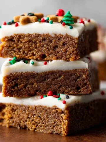 Gingerbread Cookie Bars stacked with frosting and colorful holiday sprinkles.