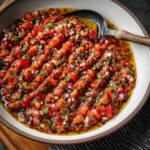 A vibrant bowl of Turkish Ezme salad with tomatoes, onions, and herbs in a rich dressing.