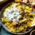 A serving of Chicken Tzatziki and Rice topped with perfectly cooked chicken pieces, fresh herbs, and a generous dollop of tzatziki sauce.