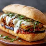 A delicious Eggplant Mozzarella Sandwiches served with marinara sauce and garnished with fresh basil.